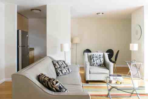 Living room with beige sofas, black and white pillows, and contemporary furniture.