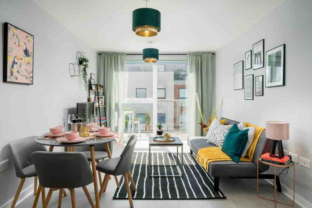 Bright living room with large window, stylish furniture, and colorful decor.