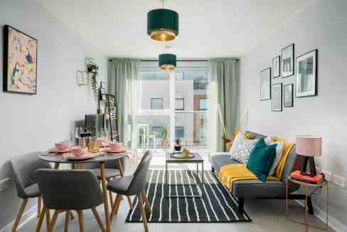 Bright living room with large window, stylish furniture, and colorful decor.