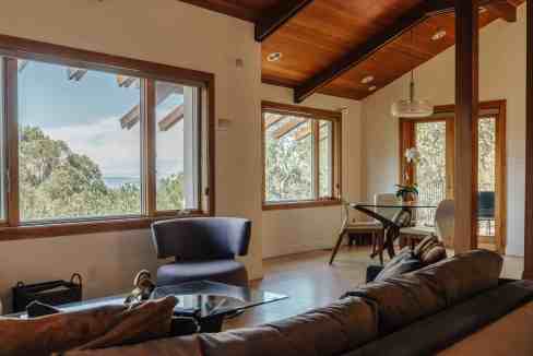 Bright living room with large windows and wooden ceiling.