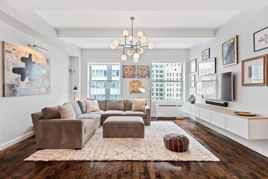 Bright living room with large windows, contemporary furniture, and modern art accents.