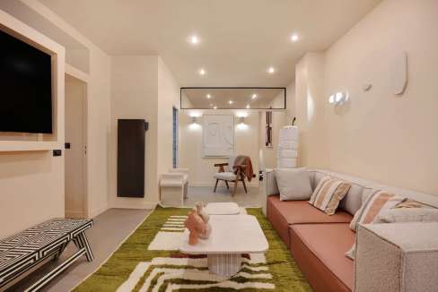 Contemporary living room with sofa, TV, and decorative elements.