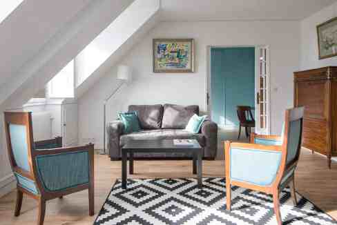 Bright living room with modern furniture and artwork in a serviced apartment.