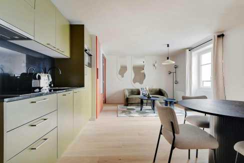 Bright, modern living space with kitchen and dining area in a serviced apartment.