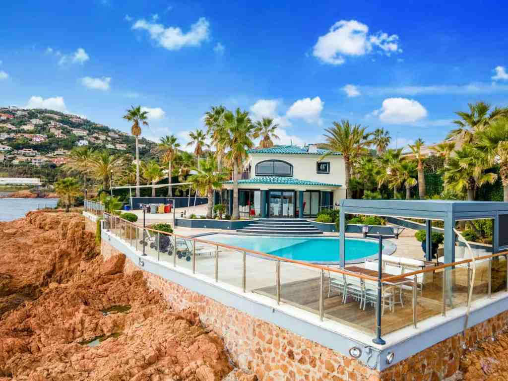 Elegant seaside villa with pool and palm trees in Cannes, France.