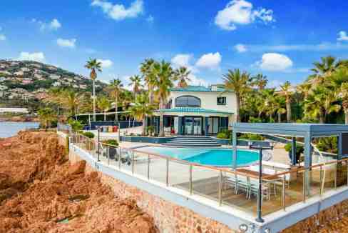 Elegant seaside villa with pool and palm trees in Cannes, France.