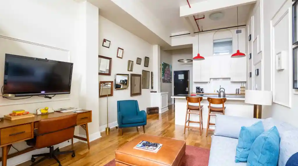 Cozy living room with modern furniture, wall art, and open kitchen in a stylish apartment.
