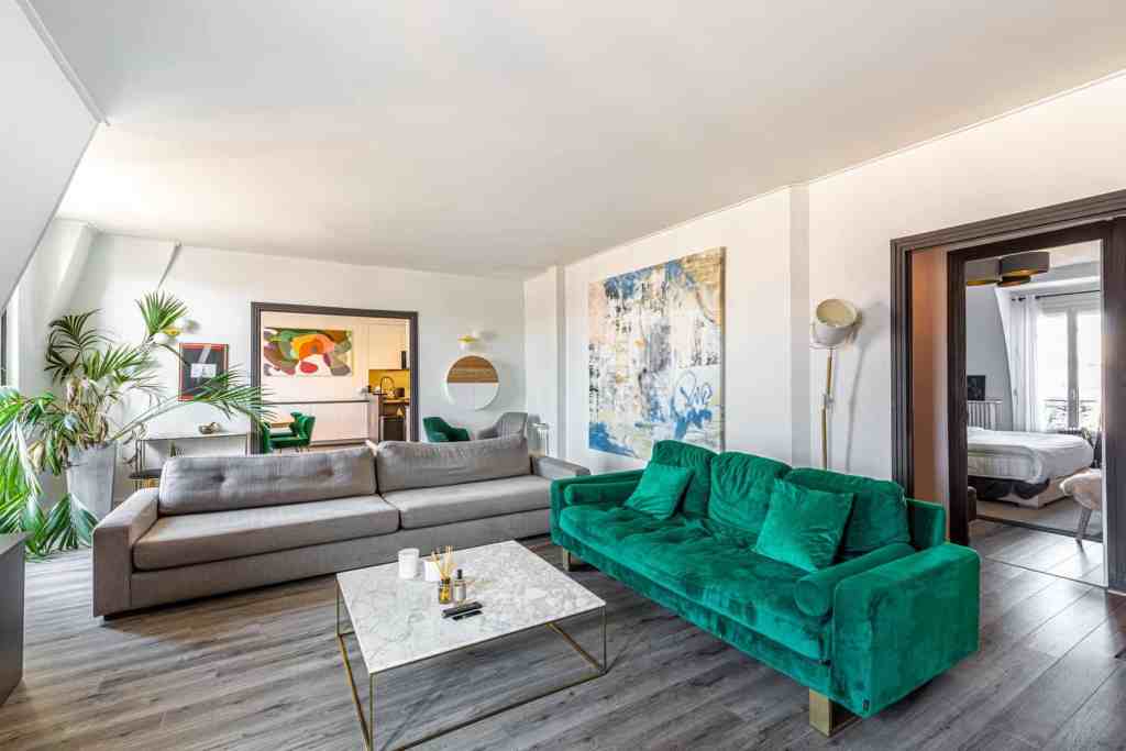 Spacious living room with colorful artwork and plush sofas in a serviced apartment.