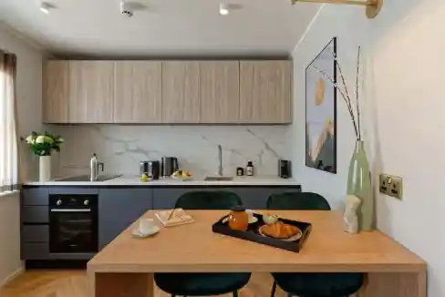 Contemporary kitchen with wooden cabinets and dining table.