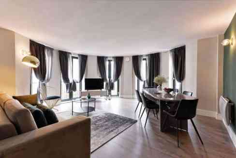 Spacious living room with large windows, modern furniture, and elegant decor in Fitzrovia.