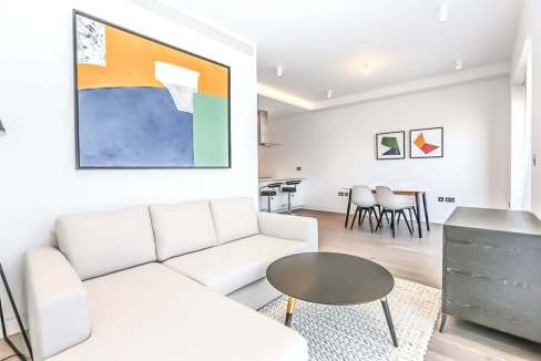 Contemporary living room with white sofa and abstract art.