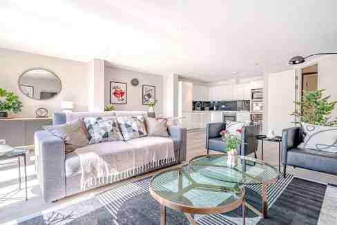 Bright and spacious living room with modern furniture and open kitchen design.
