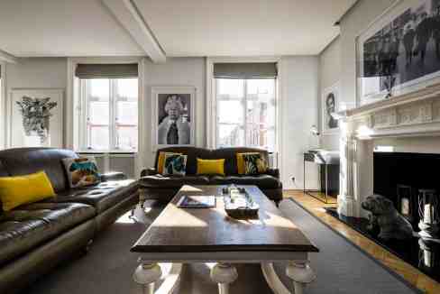 Elegant living room in Mayfair Crossview Suite with artwork and fireplace.