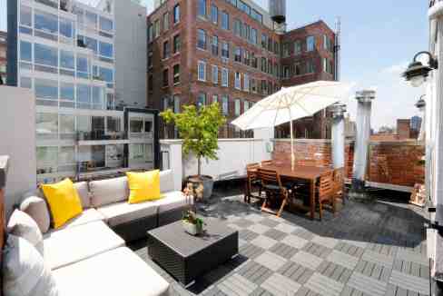 Rooftop terrace with seating, umbrella, and city views in Chelsea.