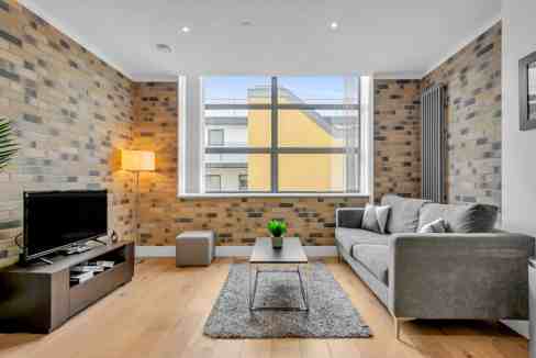 Contemporary living room with brick walls, large window, and stylish furniture.