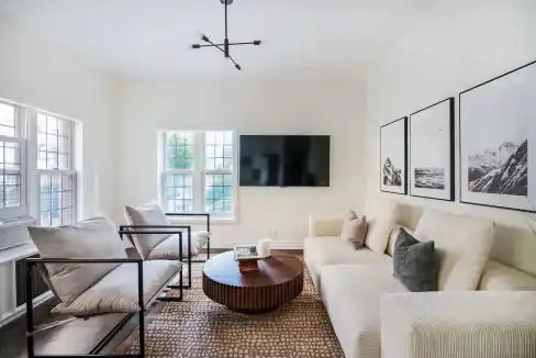 Bright living room with large windows, modern furniture, and wall art in Greenwich Village.