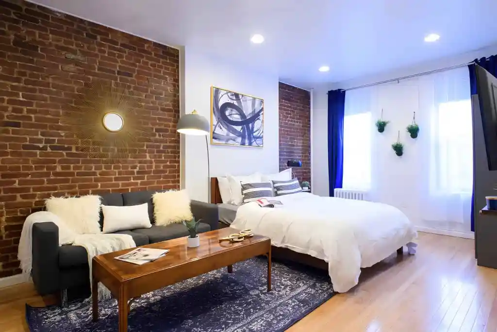Modern serviced apartment with brick wall, cozy sofa, and bright decor in Yorkville.