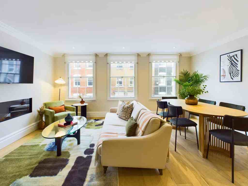Bright living room with modern furniture and large windows in Marylebone Mews.
