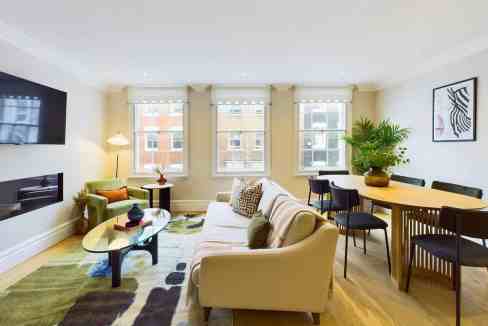 Bright living room with modern furniture and large windows in Marylebone Mews.