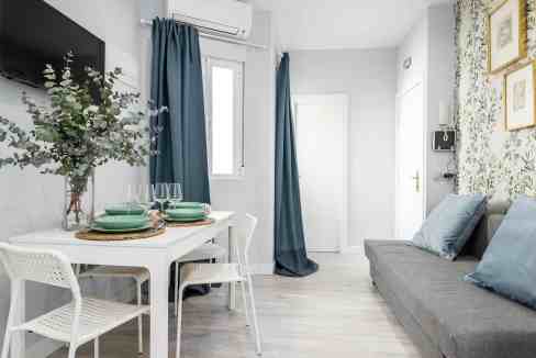 Bright living room with dining area and blue curtains at Royal Quarter Hideaway.