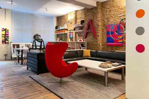 Contemporary living room with colorful artwork and stylish furniture.