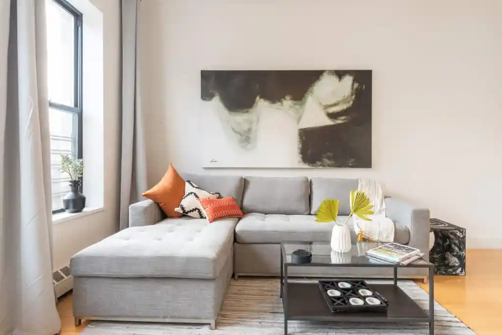 Stylish living room with gray sectional sofa and abstract wall art.