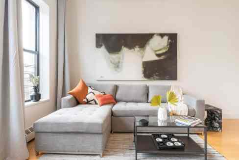Stylish living room with gray sectional sofa and abstract wall art.