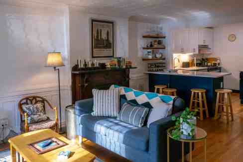 Comfortable living room with blue sofa, wooden furniture, and modern decor.