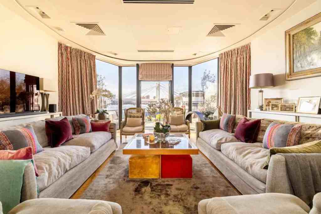 Elegant living room with large windows and stylish furniture in Chelsea Riverline Poise.