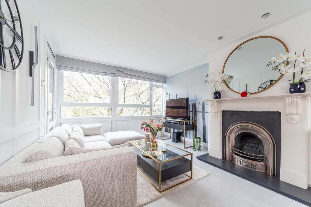 Bright living room with large windows, modern decor, and fireplace at Elephant Gallery Apartment.