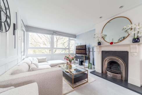 Bright living room with large windows, modern decor, and fireplace at Elephant Gallery Apartment.