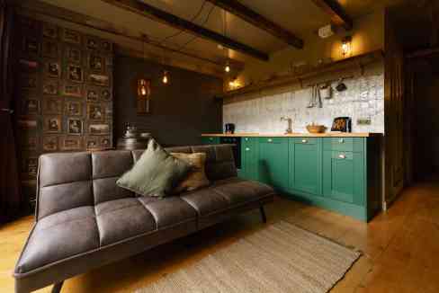 Stylish Victorian loft living room with modern kitchen and cozy sofa.