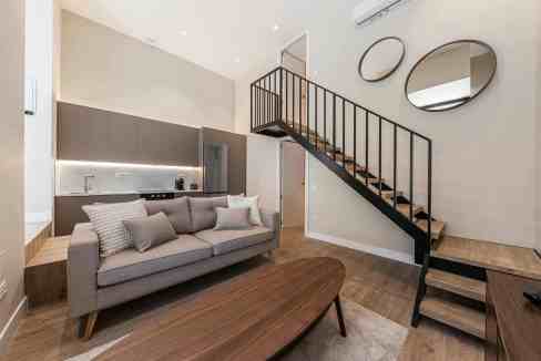 Contemporary living room with staircase and stylish decor.