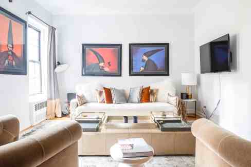 Modern living room with artwork, sofa, and TV in Sutton Townhouse.