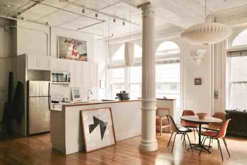Bright loft kitchen with dining space and large windows.