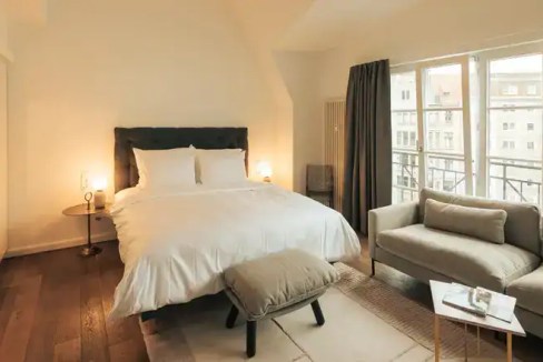Spacious bedroom with large windows and modern decor in Berlin Daylight Studio.