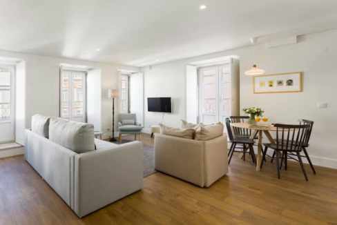 Spacious modern living room with large windows and minimalist decor.