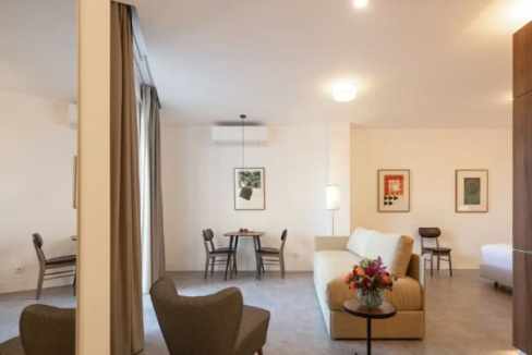 Modern serviced apartment living room with seating and artwork in Lisbon.