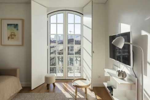 Bright living room with large arched window and modern decor.