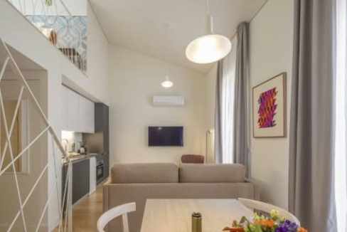 Modern serviced apartment living room with dining area and balcony view.