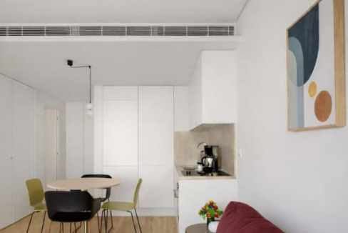 Modern Lisbon apartment with dining area and artwork on the wall.