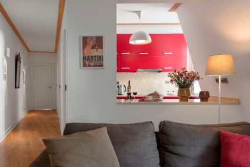 Modern living room with open kitchen and colorful decor in Palacio Camoes Sanctuary.
