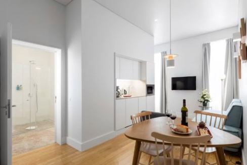 Modern serviced apartment interior with dining area and open kitchen.