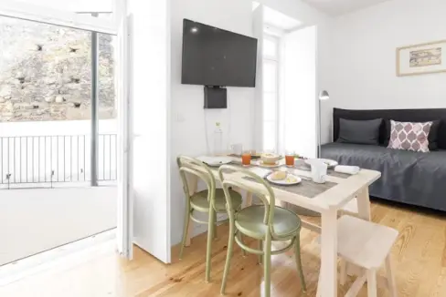 Modern Lisbon serviced apartment with dining area and balcony view.