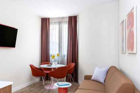 Modern living room with dining area in Fuencarral Madrid serviced apartment.