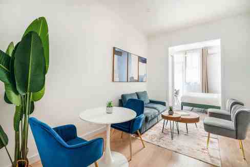 Bright living room with colorful chairs and a cozy sofa in a serviced apartment.