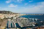 Marina in Nice, French Riviera with yachts and scenic coastline.