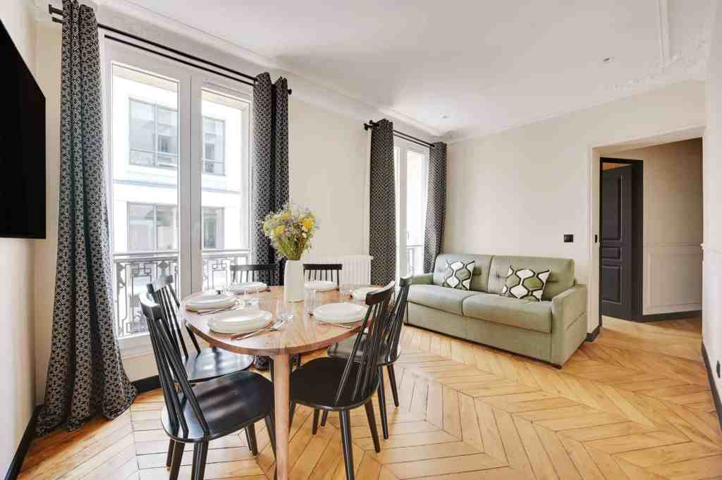 Bright living and dining area in a Paris serviced apartment with modern decor.