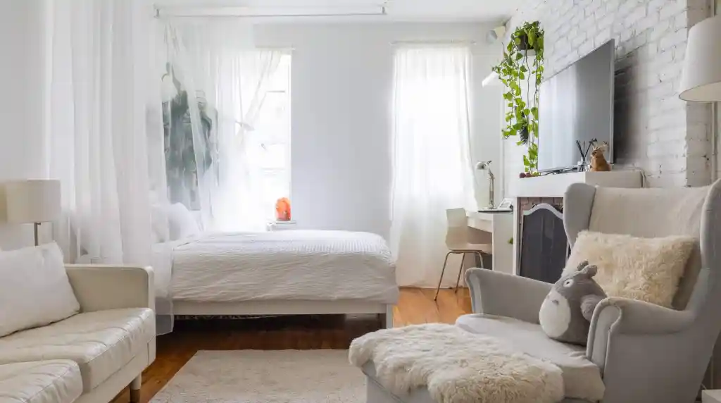 Bright and airy Chelsea studio with white decor and cozy furnishings.