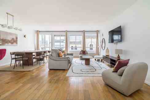 Spacious modern living room with large windows and stylish furniture.